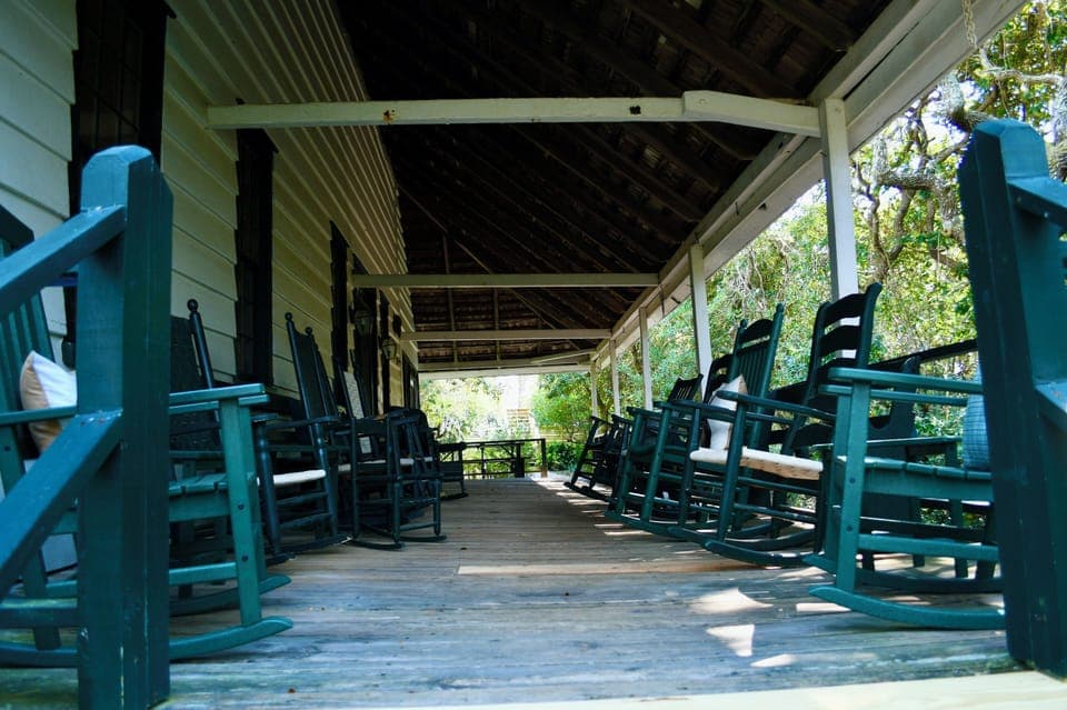 Side porch, ample seating for a crowd. Walkway to the beach in the background.