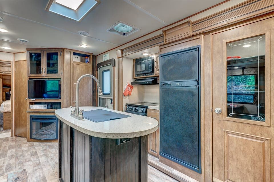 Versatile space featuring a Smart TV, cozy sofa, dining area, and kitchen
