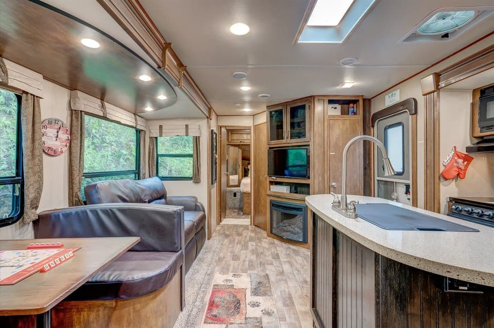 Versatile space featuring a Smart TV, cozy sofa, dining area, and kitchen