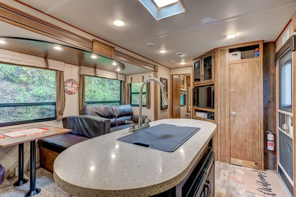Versatile space featuring a Smart TV, cozy sofa, dining area, and kitchen