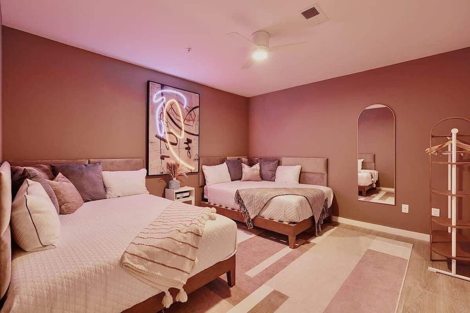 Bedroom 4: 2 Queen size bed with a warm, earthy color palette, plush bedding, and a striking abstract artwork