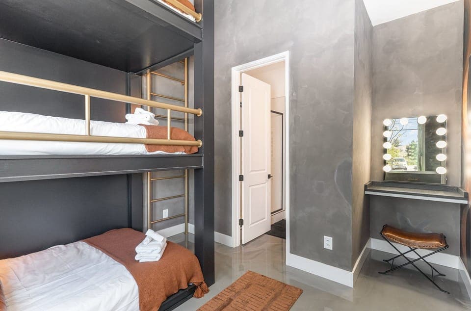 1st Unit (1st Floor): 4th Bedroom featuring a Bunk Bed with 3 Full beds, Get Ready Vanity, Smart TV, and en-suite bathroom.