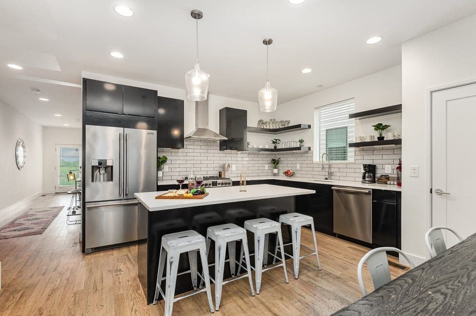 Unit 3: Fully Equipped Kitchen with stainless steal appliances, bar seating, and a dining area.