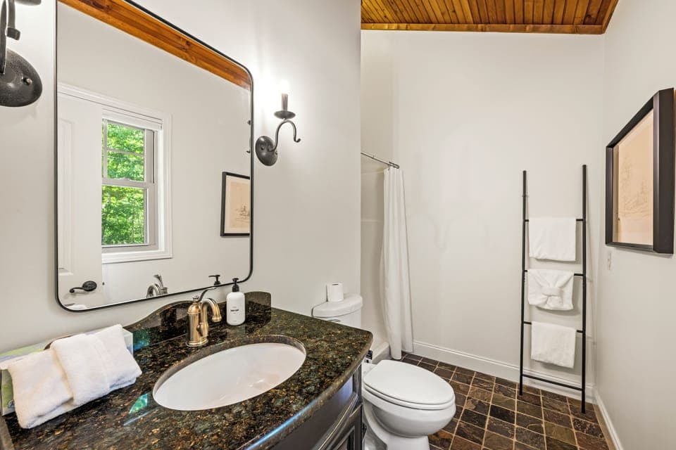 Stylish bathroom with warm wood accents, sleek granite vanity, and spa-like touches for a refreshing stay.