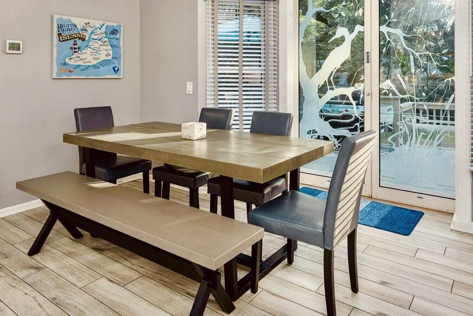 In addition to the kitchen island stools, guests can dine at this table located right next to the kitchen. From the dining area, look through the gorgeous etched glass doors to see the large backyard. The spacious deck and grill are right through the door