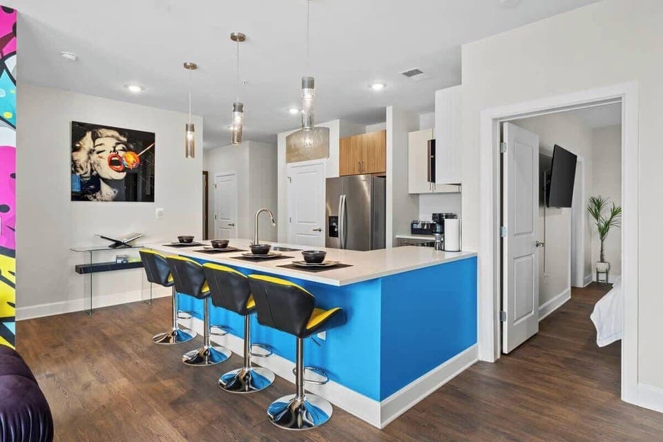 - Sleek open kitchen with bright blue island  
- Modern appliances perfect for cooking  
- Bar seating ideal for group travel  
