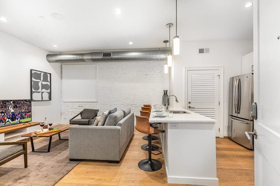 Unit 1: Open-concept living area featuring cozy furnishings, smart TV, and a sleeper sofa. (4th Floor)