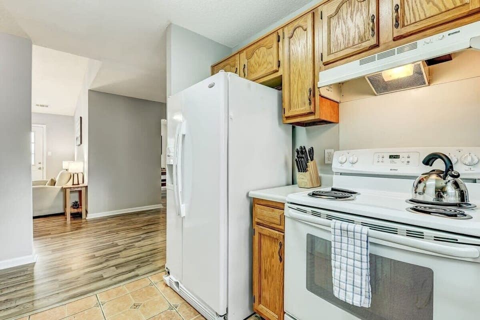 Kitchen view with refrigerator, stove, and counter space for daily cooking needs.