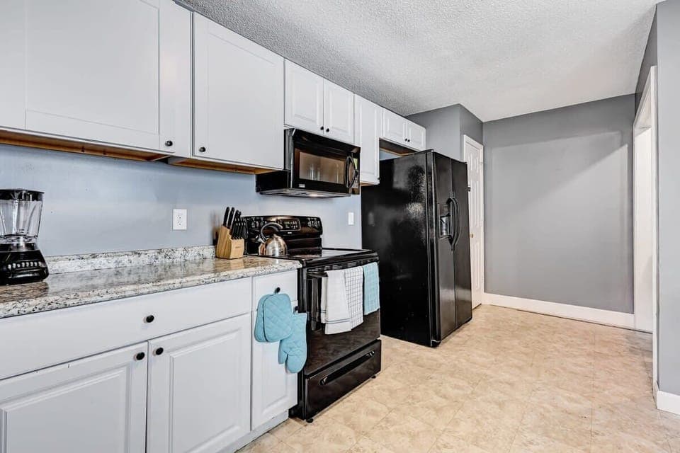 Well-equipped kitchen with black appliances and efficient layout.
