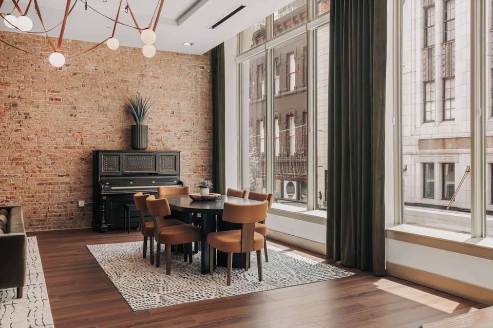 The dining room features a spacious table surrounded by six comfortable, design-forward chairs—perfect for shared meals or game nights.