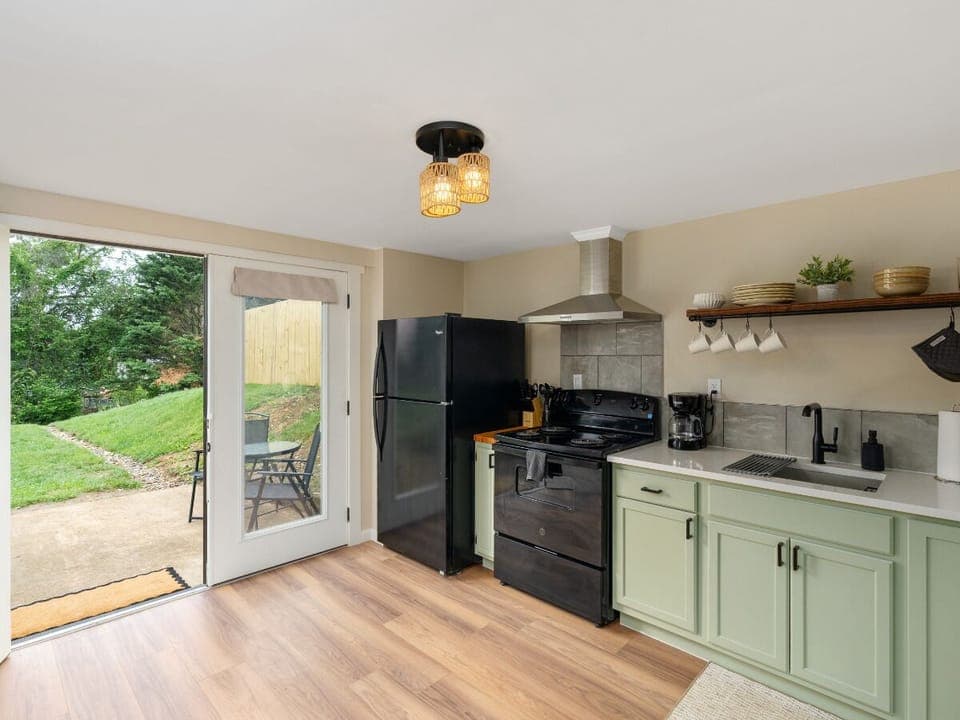 Cook with a view—this clean kitchen features a glass door that lets the outside in! ☀️