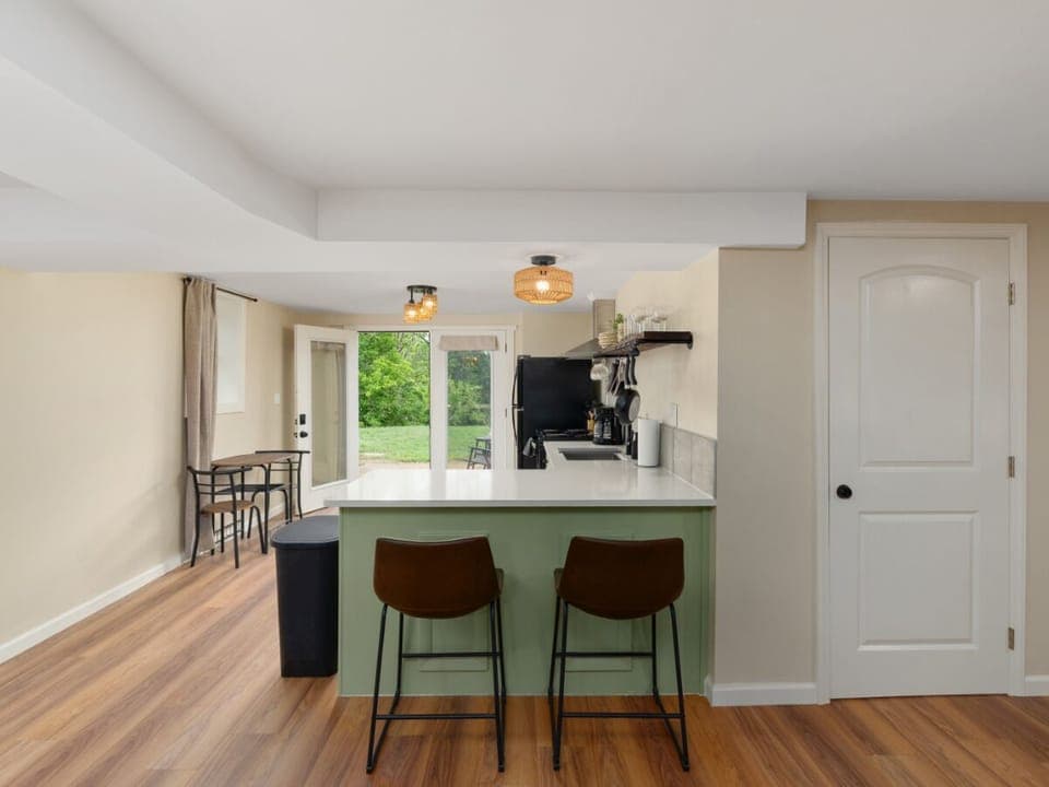 Whip up meals in this bright kitchen with outdoor views and enjoy them at the nearby bar table. ☀️
