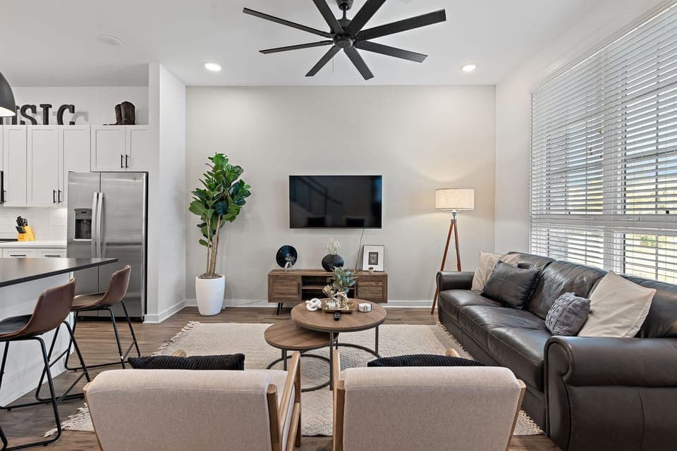 Stylish, clutter-free living room with mounted TV and leather seating.