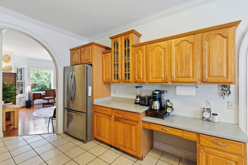 Fully equipped kitchen with coffee station and stainless steel fridge.