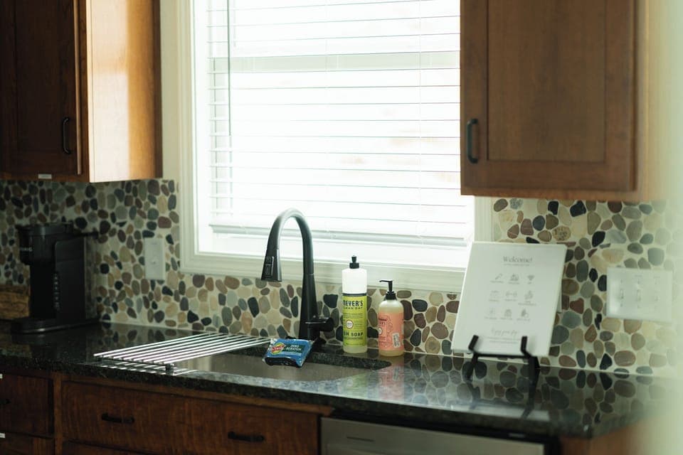 Kitchen sink with cleaning supplies and welcome binder