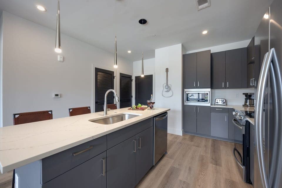 Unit 1: Fully equipped kitchen with brand-new stainless-steel appliances and a Kitchen island that offers ample counter space and bar seating.