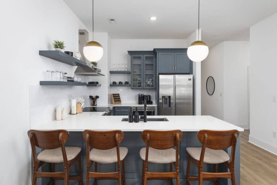 Condo 1 - Fully-stocked kitchen with high-end appliances and seating for 4 at the kitchen counter.