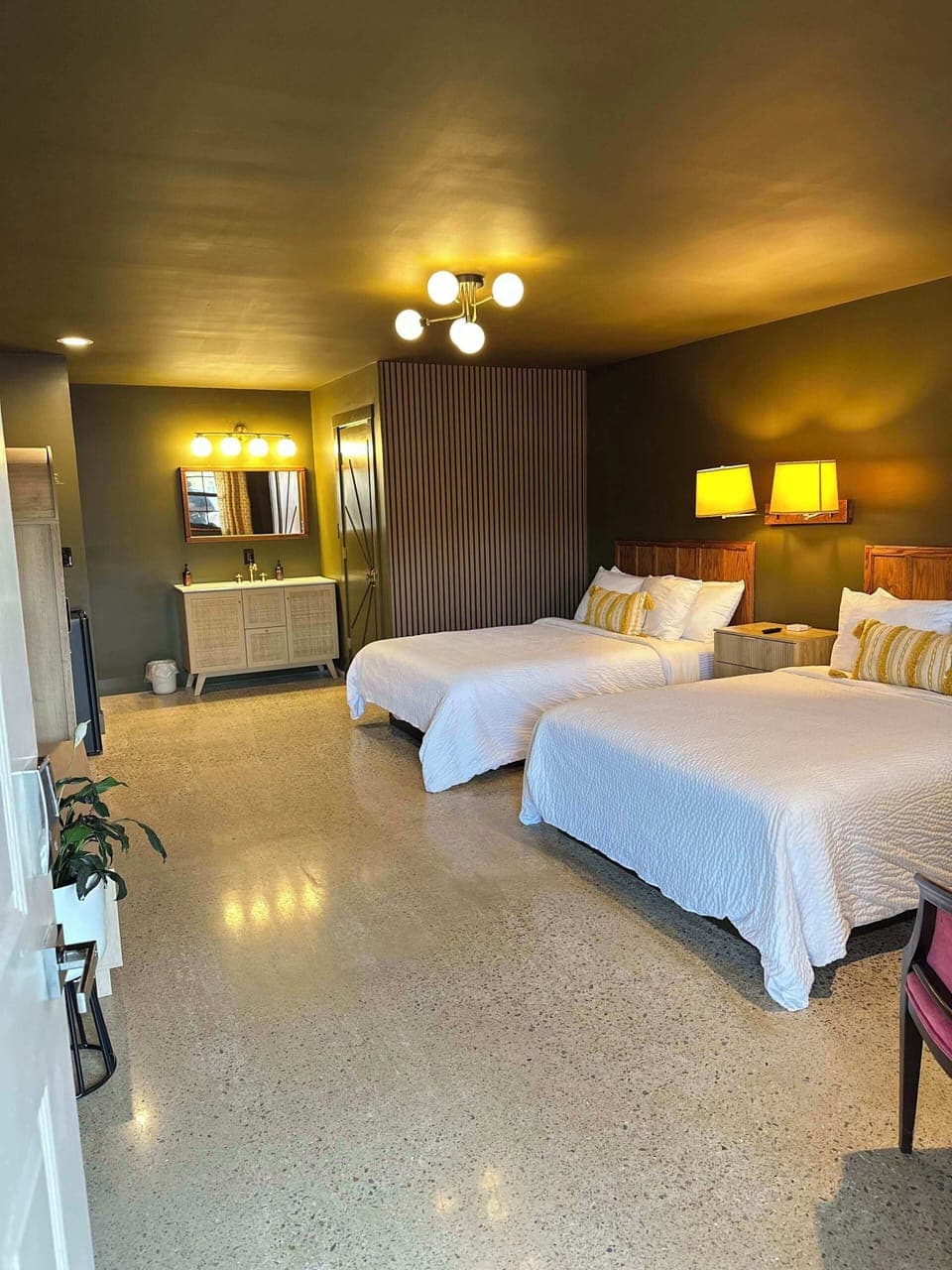 2 queen beds with sitting area for 2, TV console, smart TV, bookcase with hot water kettle, french press, microwave, mini fridge, sink vanity with towels and wash cloths