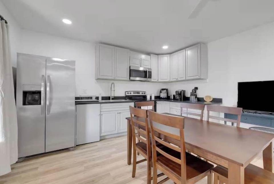 Adjacent to the living area is a dining table, ideal for enjoying meals with family and friends. Whether you're having a casual breakfast, a home-cooked dinner, or planning a game night, the dining space offers both convenience and charm.