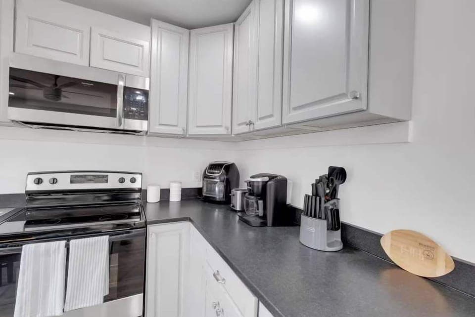 The kitchen is a chef's dream, combining modern design with all the essentials for a comfortable stay. It features a full suite of high-quality stainless steel appliances, including a refrigerator, cooktop, and oven, making meal preparation a breeze.