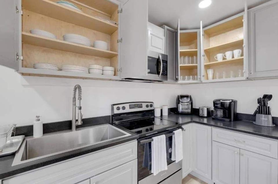 The sleek countertops and ample storage space ensure you have room to work and organize your kitchen essentials. The kitchen also comes fully equipped with pots, pans, utensils, and a coffee maker to enhance your cooking experience.