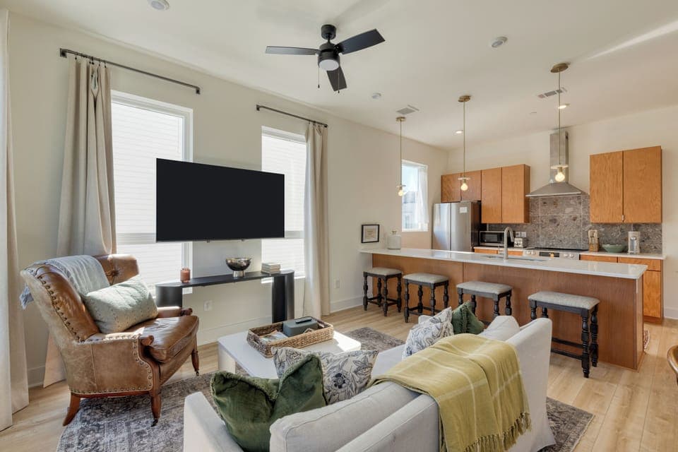 The living room features a large window and a chic modern design.