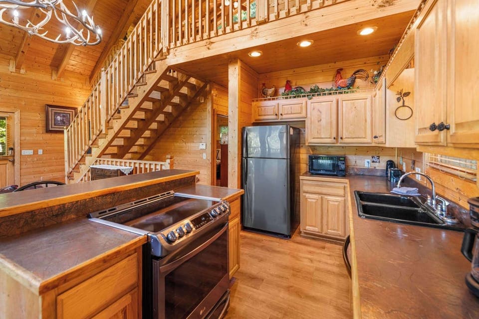 Fully equipped kitchen with stainless steel appliances & bar seating.