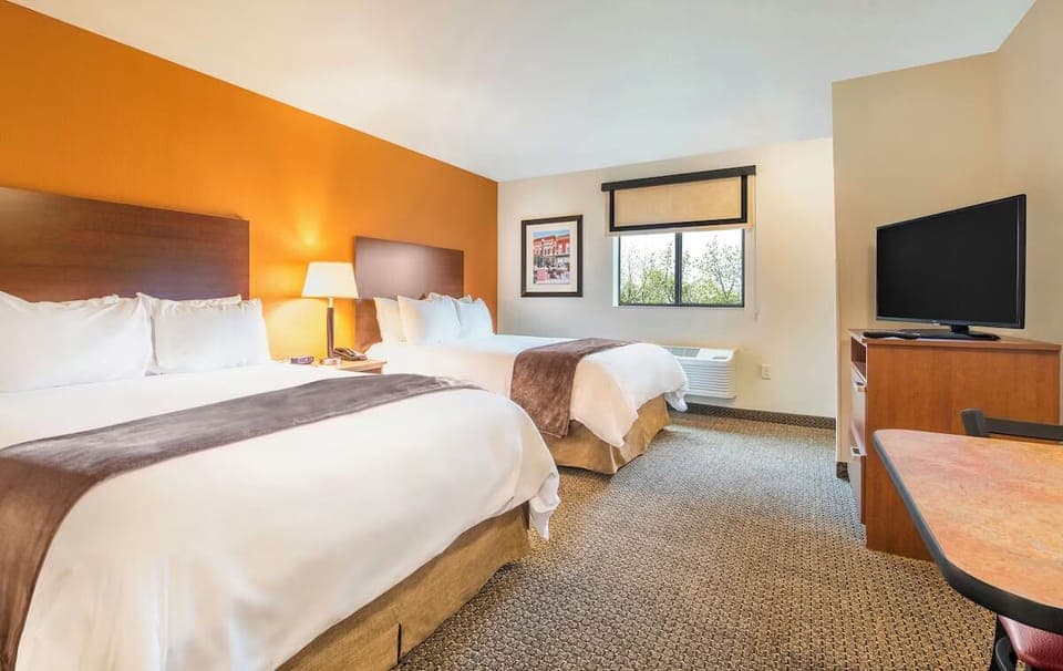 Relax in a bright double-queen room with TV and workspace.