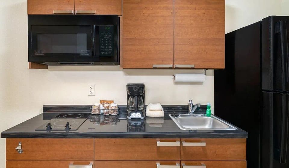 Prepare simple snacks with fridge, microwave, and sleek counters.