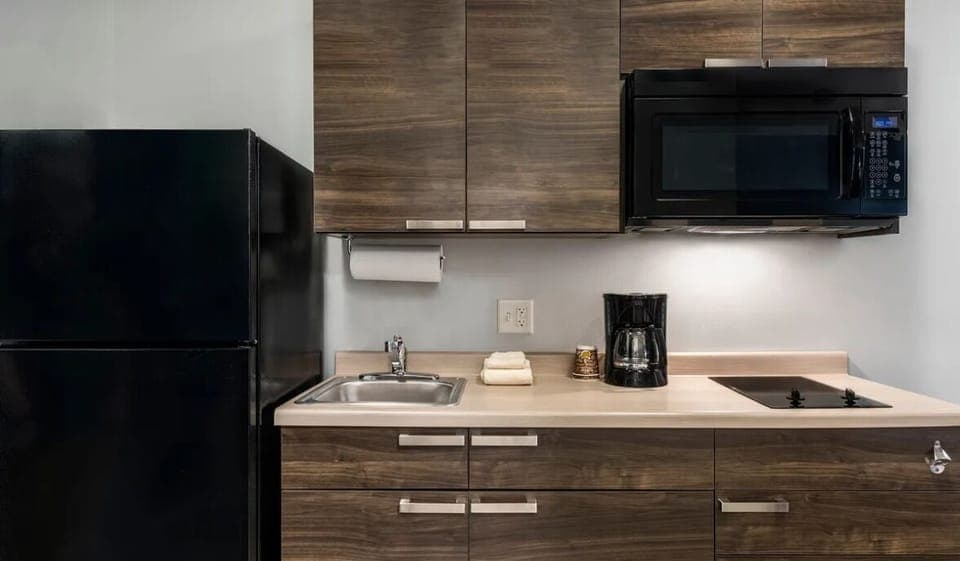 Brew coffee and prep snacks with fridge, microwave, and cooktop