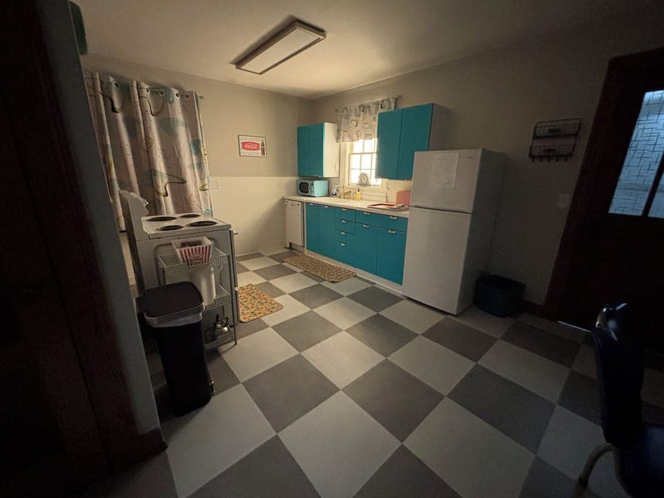 Night time magical view of kitchen with lit faux window. Door to backyard