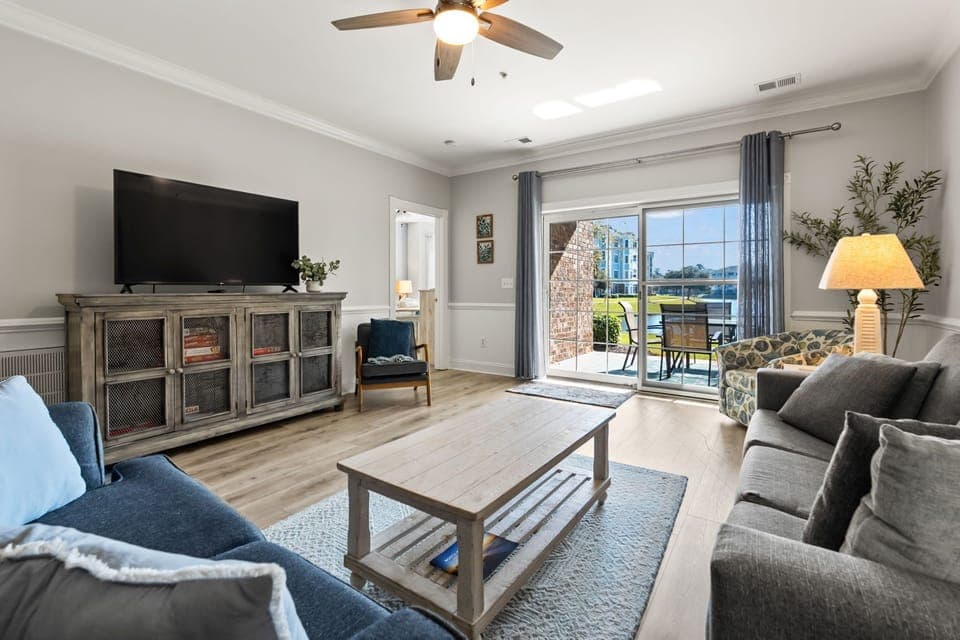 A cozy TV lounge with a clear view of the sunroom, offering natural light and a relaxing atmosphere—perfect for enjoying entertainment or unwinding in a bright, inviting space.