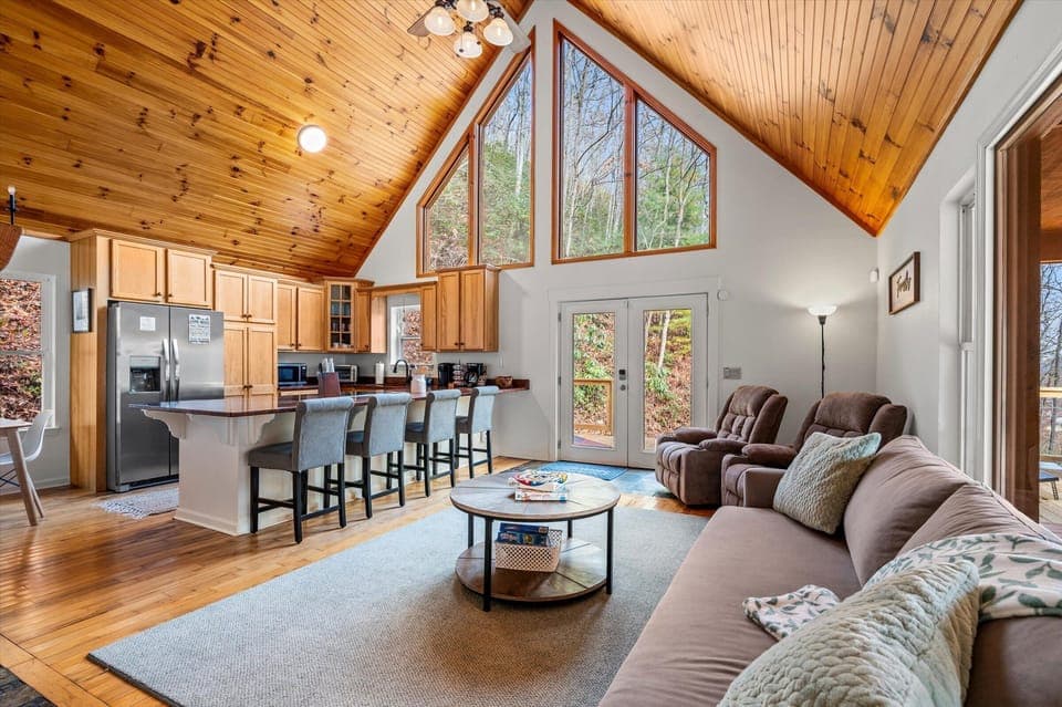 Open-concept living: kitchen bar, seating, and vaulted ceiling.