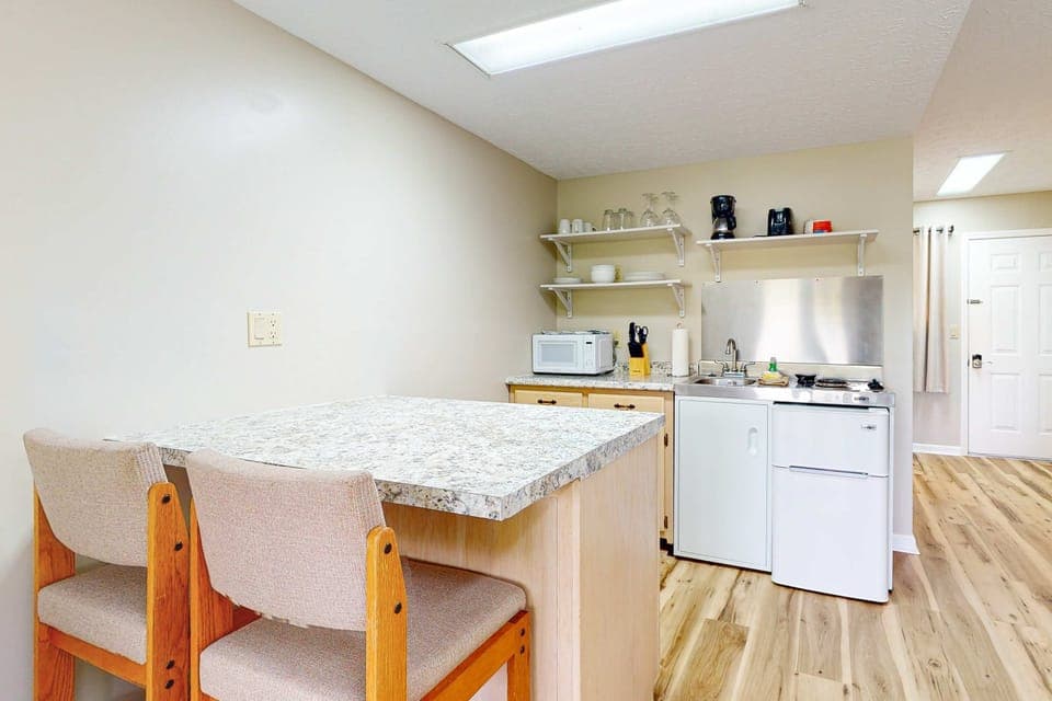 Eat-in granite breakfast bar with two chairs plus full kitchenette. Perfect for quick bites, coffee, and work-from-home setup in this convenient studio.