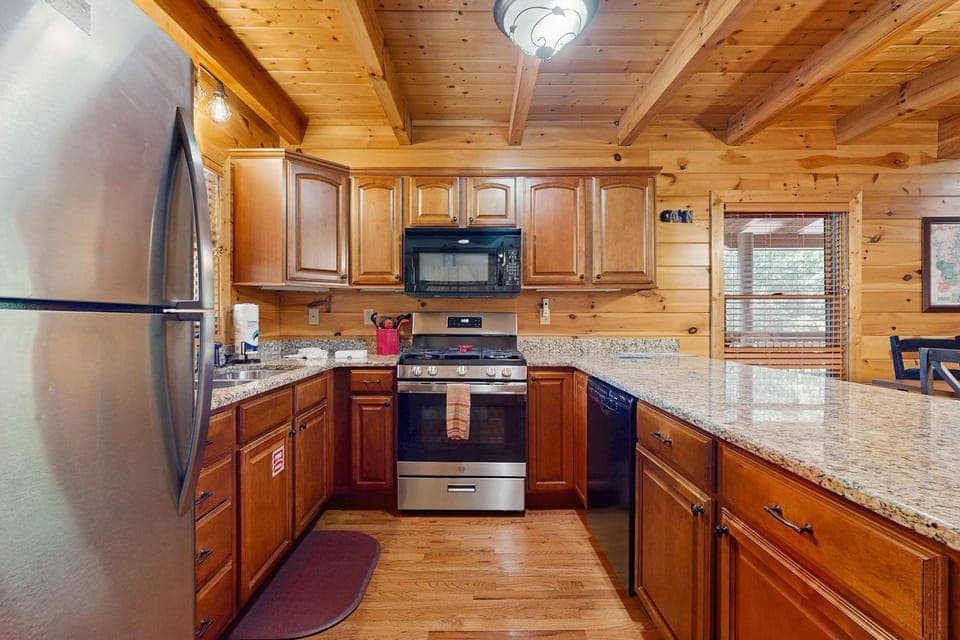 Spacious cabin dining area with open layout, vaulted ceilings, and cozy living room. Perfect for family gatherings, Smoky Mountain vacations, Gatlinburg weekends, and Pigeon Forge adventures.