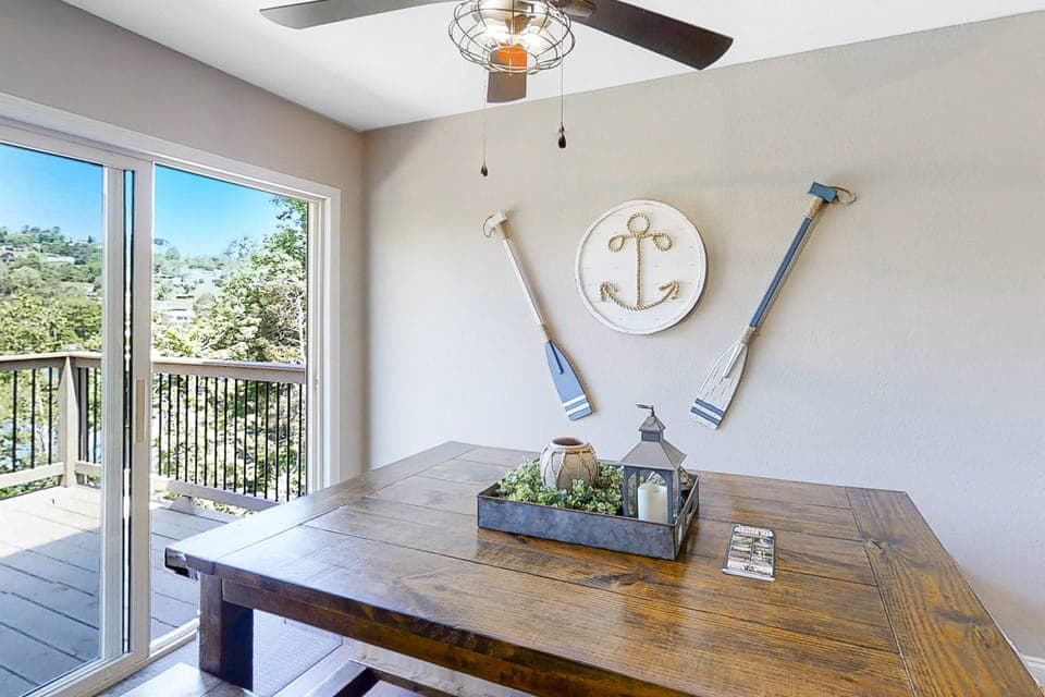 Dining space with large table and sliding doors to the deck. Ideal for meals and gatherings; easy indoor/outdoor flow, lake views, and bright natural light for family vacations and group stays.