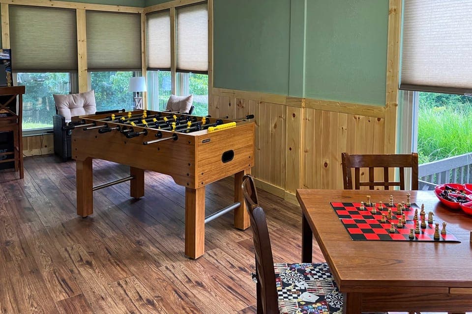 Fun-filled game room featuring foosball table, board games, and cozy seating. Ideal for families, kids, and rainy-day entertainment.