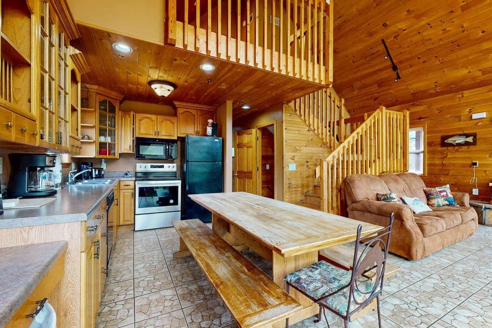 Stunning kitchen & living area awaits. And, enjoy meals at the rustic wooden table and relax on the comfy couch!