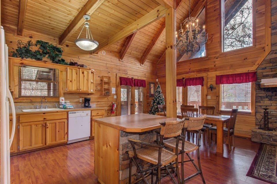 Gather around your rustic kitchen island where warm wood tones and soaring cathedral ceilings create the perfect space for morning coffee.