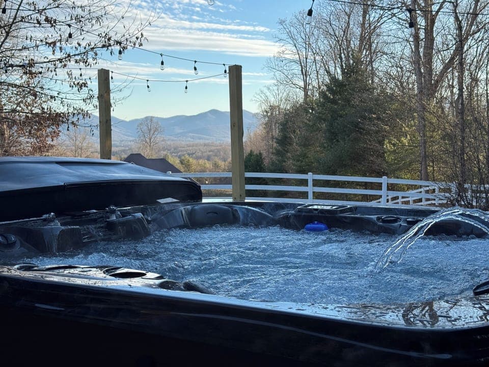 Soak in the bubbling hot tub with stunning Blue Ridge Mountain views — your private spa retreat in the mountains.