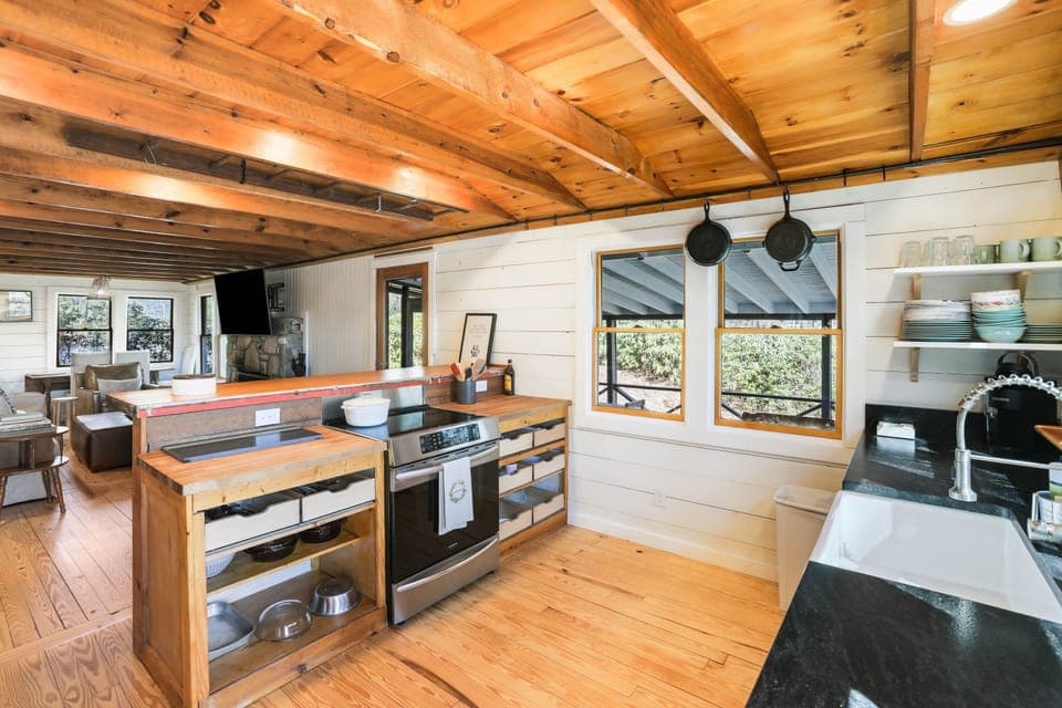 The rhythm of the day settles here. A simmering pot, the clink of dishes, laughter drifting in from the living room. This is the heart of the cabin, where simple meals become shared moments, and every task feels a little more meaningful in the quiet of the mountains.