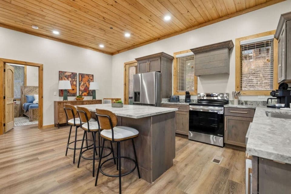 Whip up a pancake breakfast or a full family dinner in this stylish, fully stocked kitchen. Stainless appliances, warm wood cabinetry, and a central island bar make it a space everyone will want to gather in.