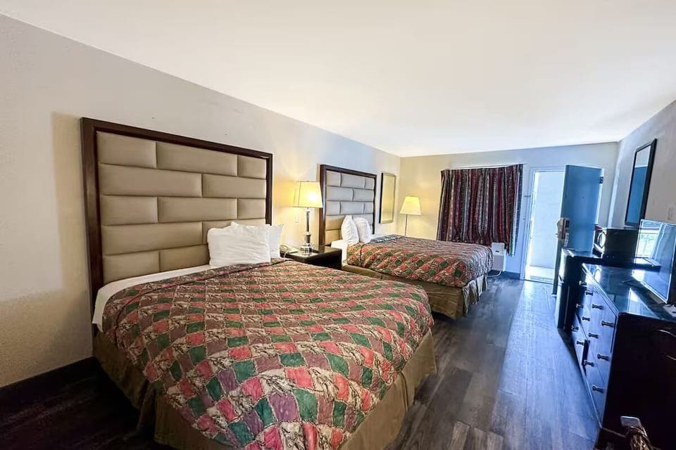 Unwind in a bright double-queen room with cozy lighting.