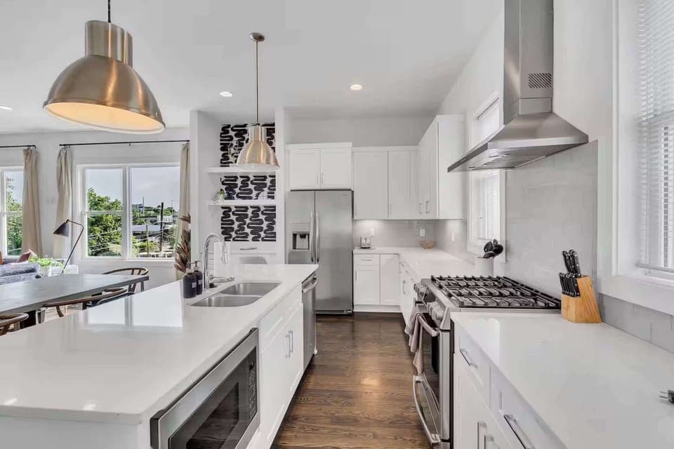 Open-concept kitchen with quartz counters, gas range, and stainless appliances. | Unit A