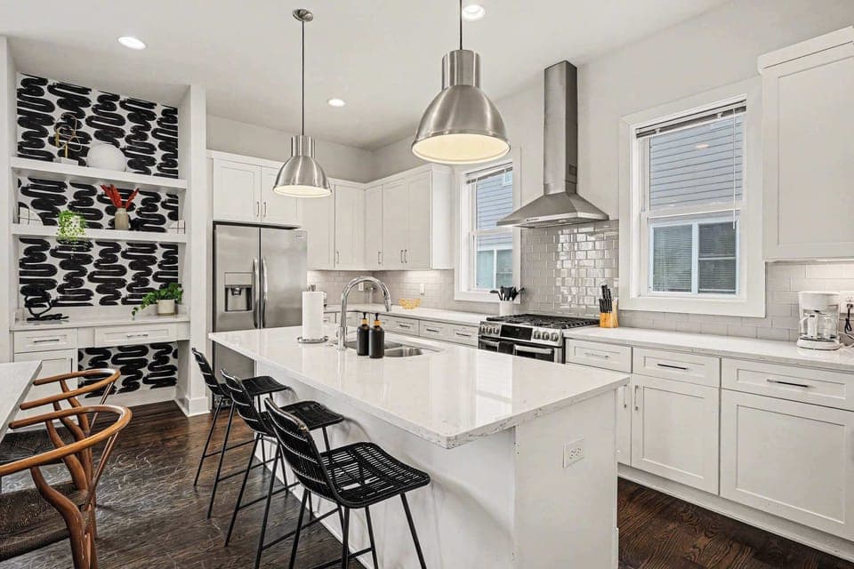Open-concept kitchen with quartz counters, gas range, and stainless appliances. | Unit A