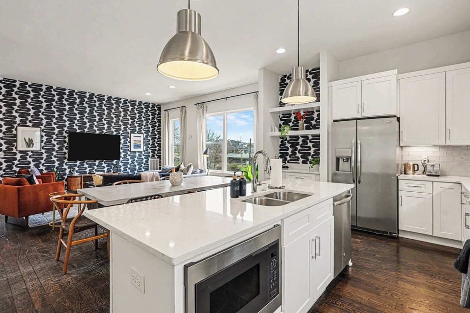 Open-concept kitchen with quartz counters, gas range, and stainless appliances. | Unit A