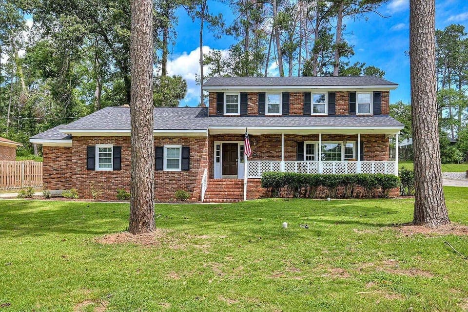 Welcome to your charming retreat! A classic brick exterior and lush green lawn greet you, perfect for arriving in style.