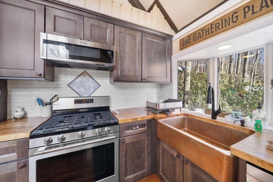 Gas Stove and Farm-Style Copper Basin Sink in the Kitchen with Wood Counters