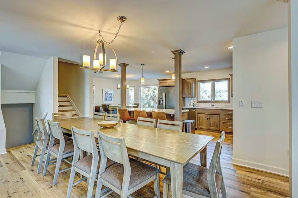 Gather around the spacious dining table where your group can share meals and make memories in this open-concept living space.