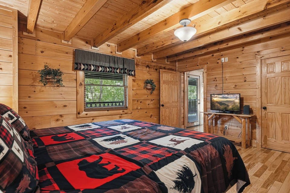 Cozy log cabin bedroom with rustic charm, warm wood beams, and nature-themed quilted bedding for peaceful mountain retreat nights.
